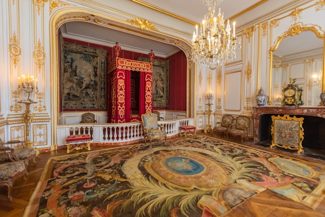 Royal bedroom with tapestries and chandeliers at Château de Chambord, France